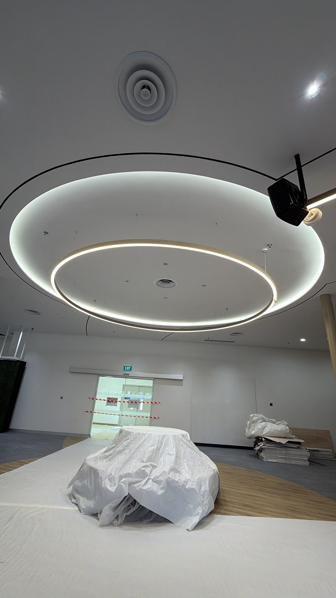 Layered circular suspended and perimeter lighting during an interior installation